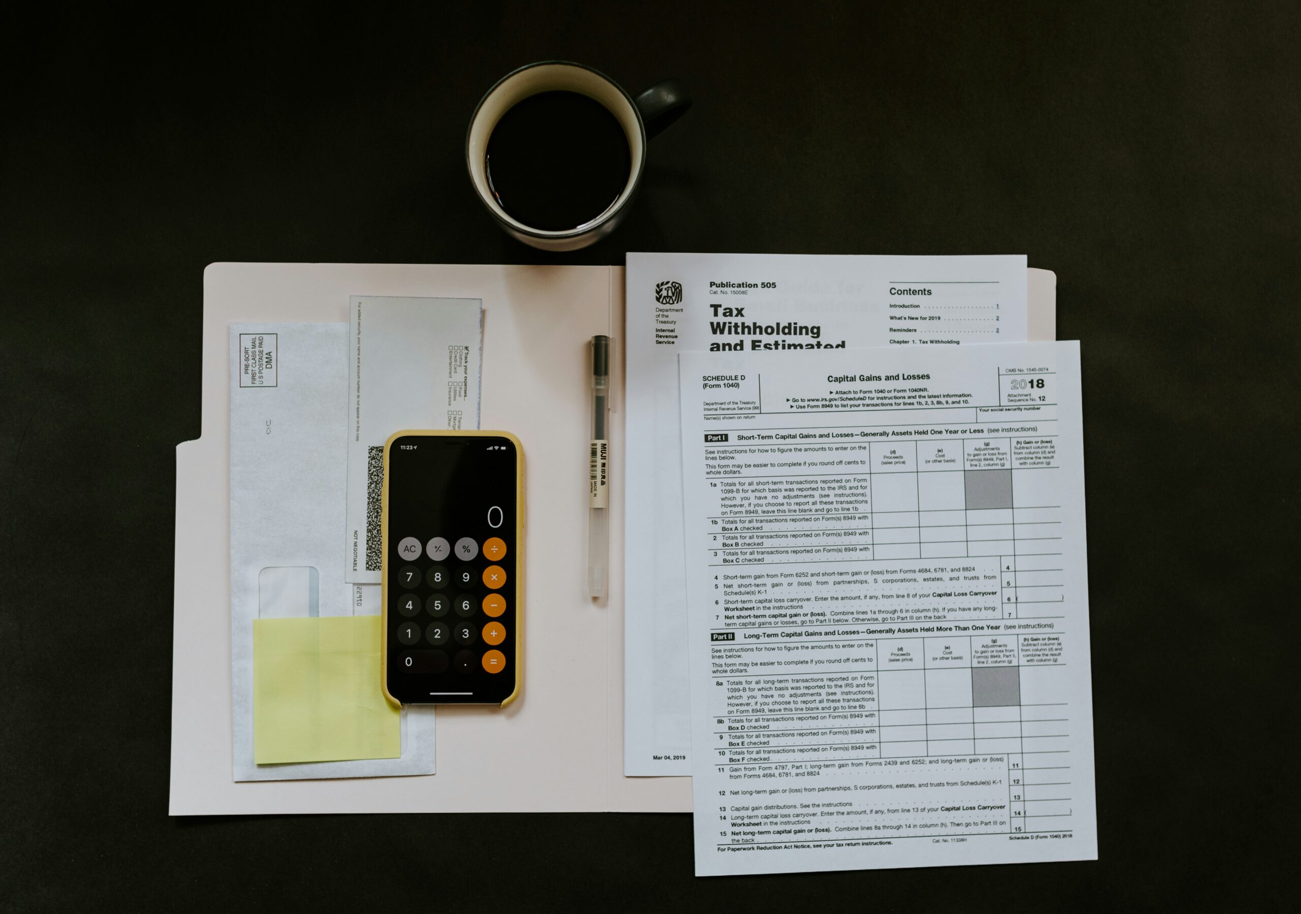 Professional accountant reviewing financial documents at a modern office desk with laptop and calculator.